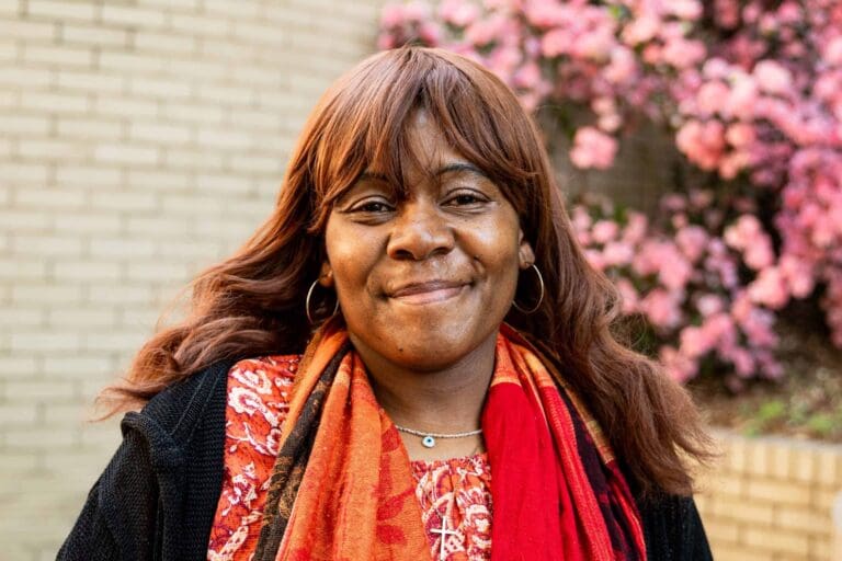 Smiling woman with flowers in background