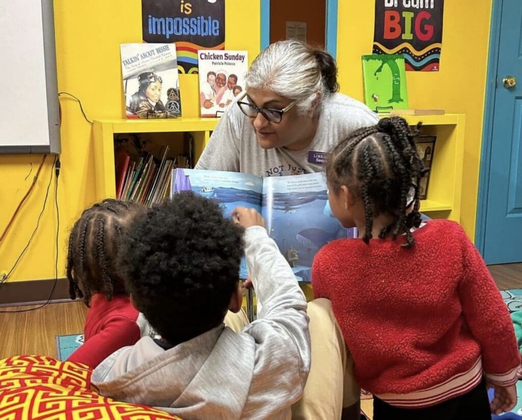 Teacher reading a picture book to children.