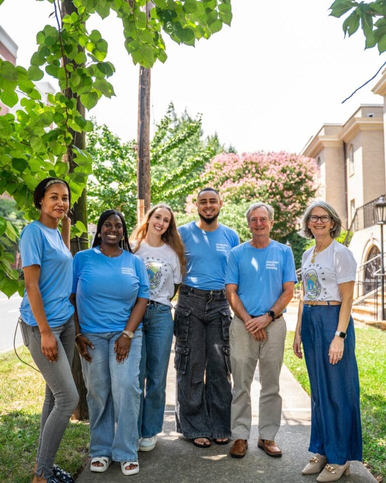 Smiling group of CFH Employees standing outdoors in new branded t-shirts.